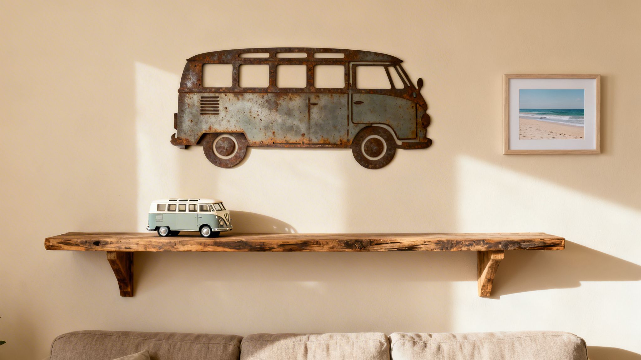 A cozy living room wall with rustic metal VW van art, a wooden shelf, and a framed beach photo.