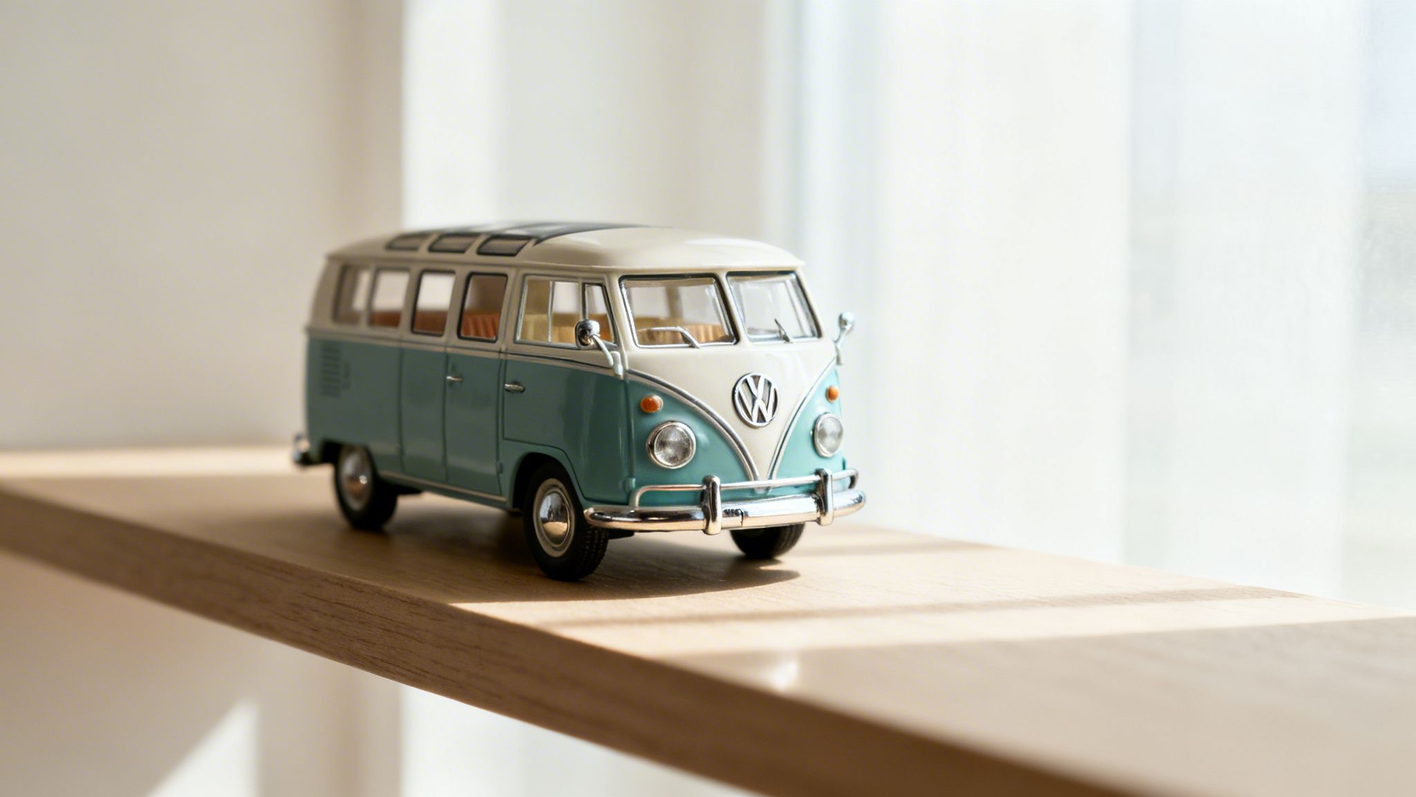 Close-up of a miniature vintage Volkswagen T1 camper van model on a sunlit shelf.