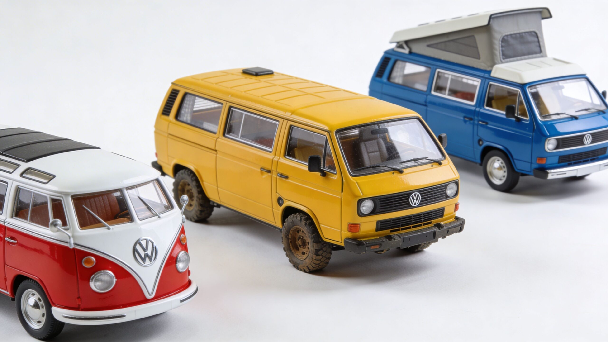 Three miniature Volkswagen vans including a red and white classic van and two modern camper van models.