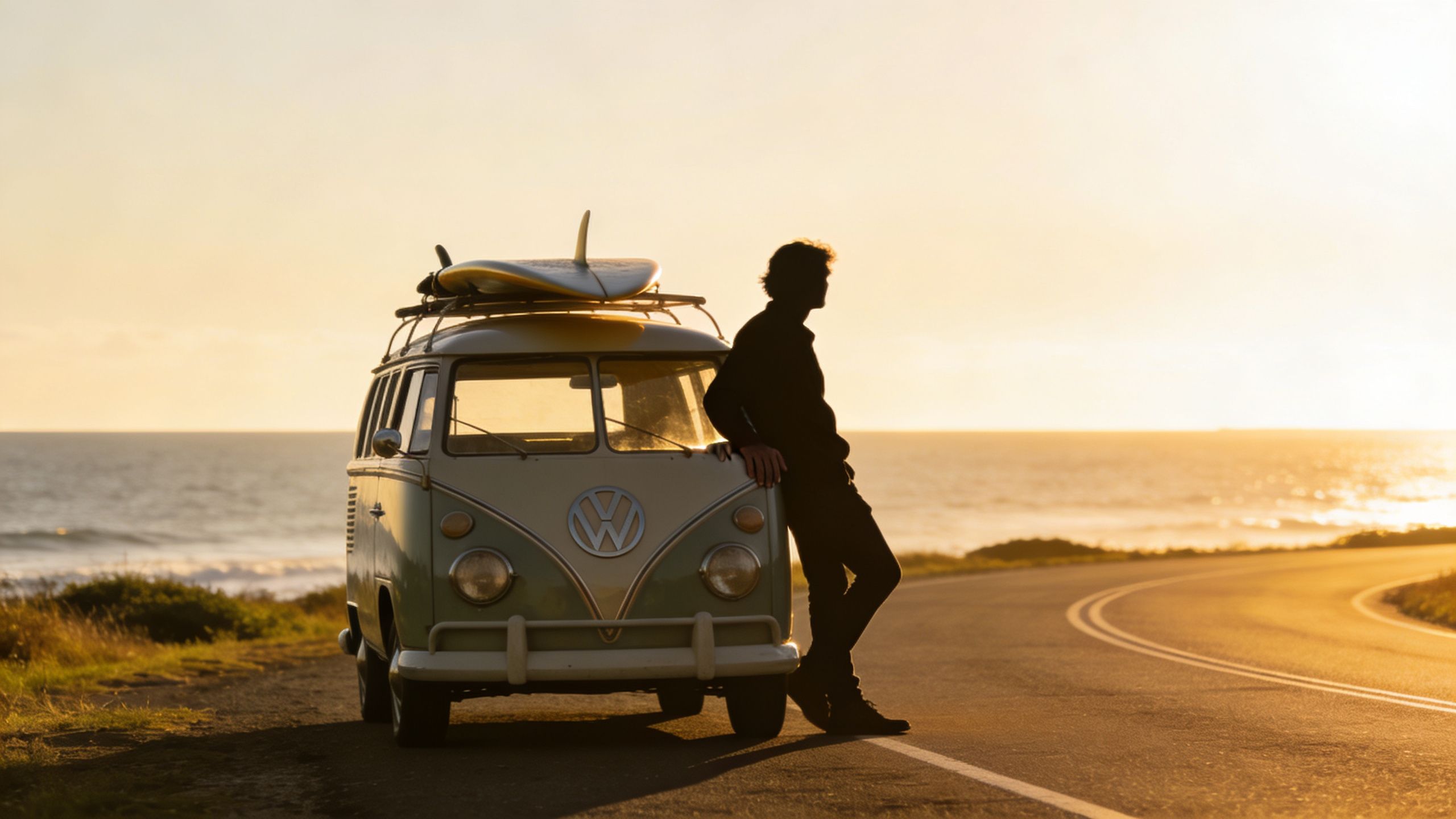 A silhouette of a man leaning against a vintage Volkswagen Kombi van with a surfboard at sunset.