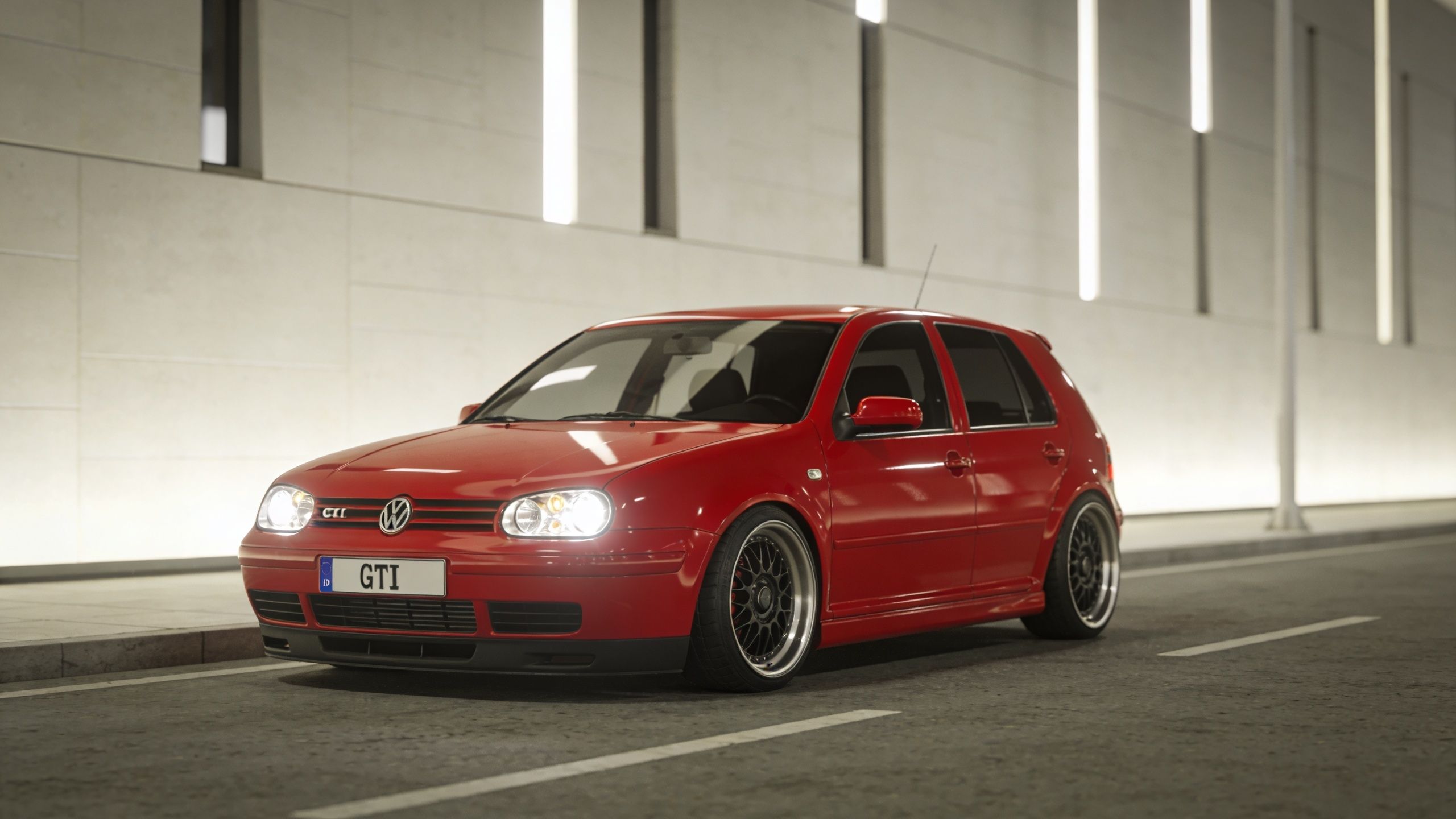 A vibrant red modified Volkswagen Golf Mk4 GTI parked on a clean, modern city street at night.