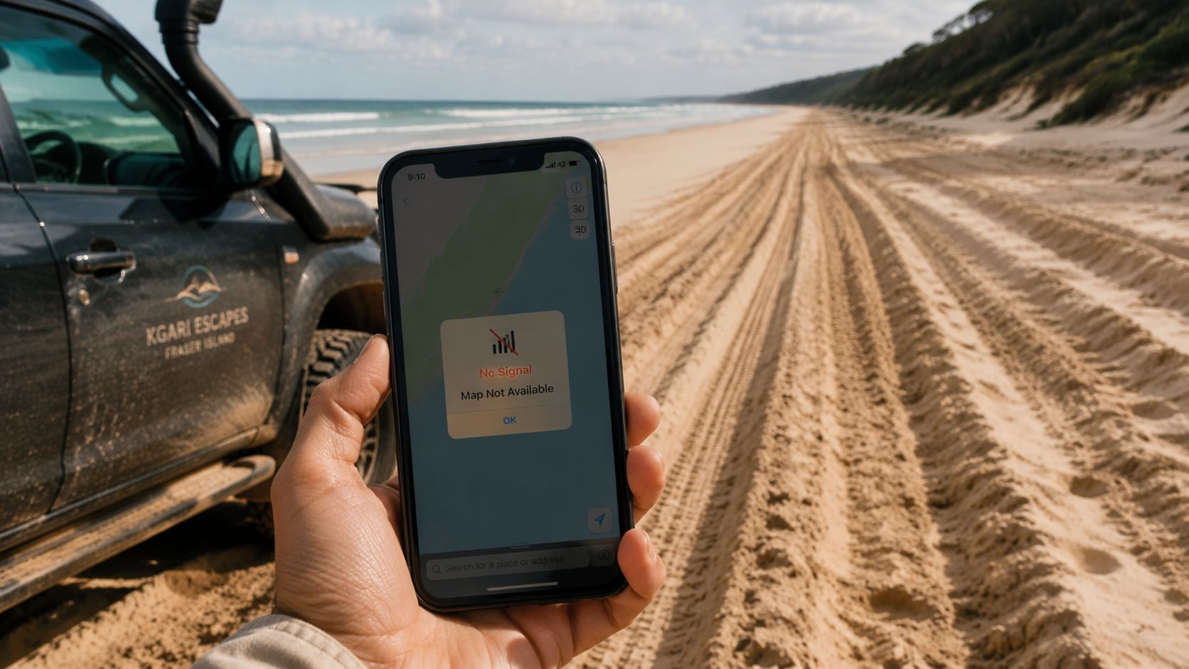 A hand holding a smartphone showing a no signal map error on a beach next to a vehicle.