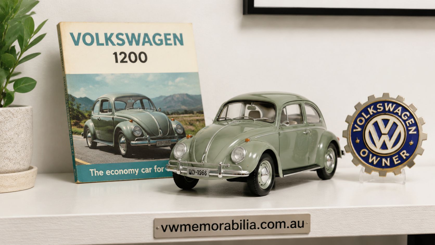 A miniature green Volkswagen Beetle model sitting on a white shelf next to a vintage Volkswagen book.