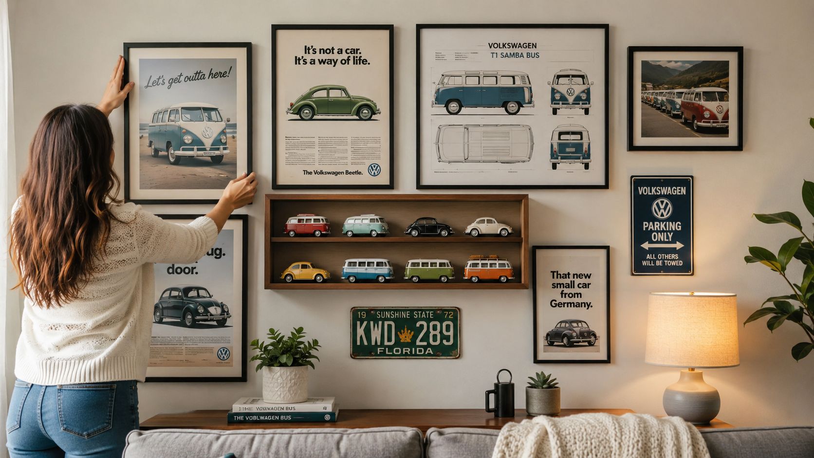 A woman hanging Volkswagen themed wall art and displaying die-cast model cars in a cozy living room.