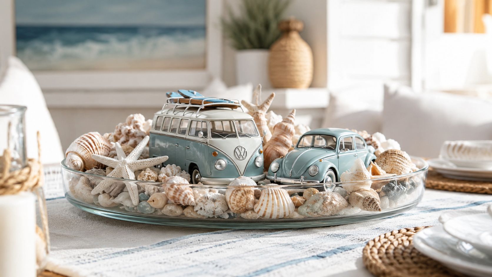 A glass bowl filled with seashells, a starfish, and miniature vintage Volkswagen bus and beetle toy cars.