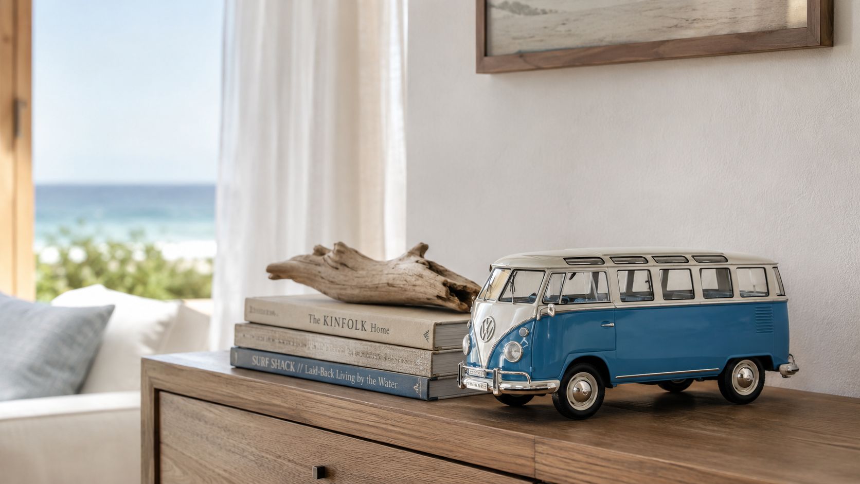 A classic blue and white toy Volkswagen bus sits on a wooden shelf next to books.