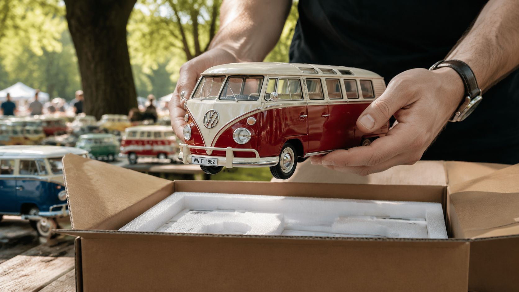 A person holding a detailed miniature model of a classic red and white Volkswagen T1 camper van.