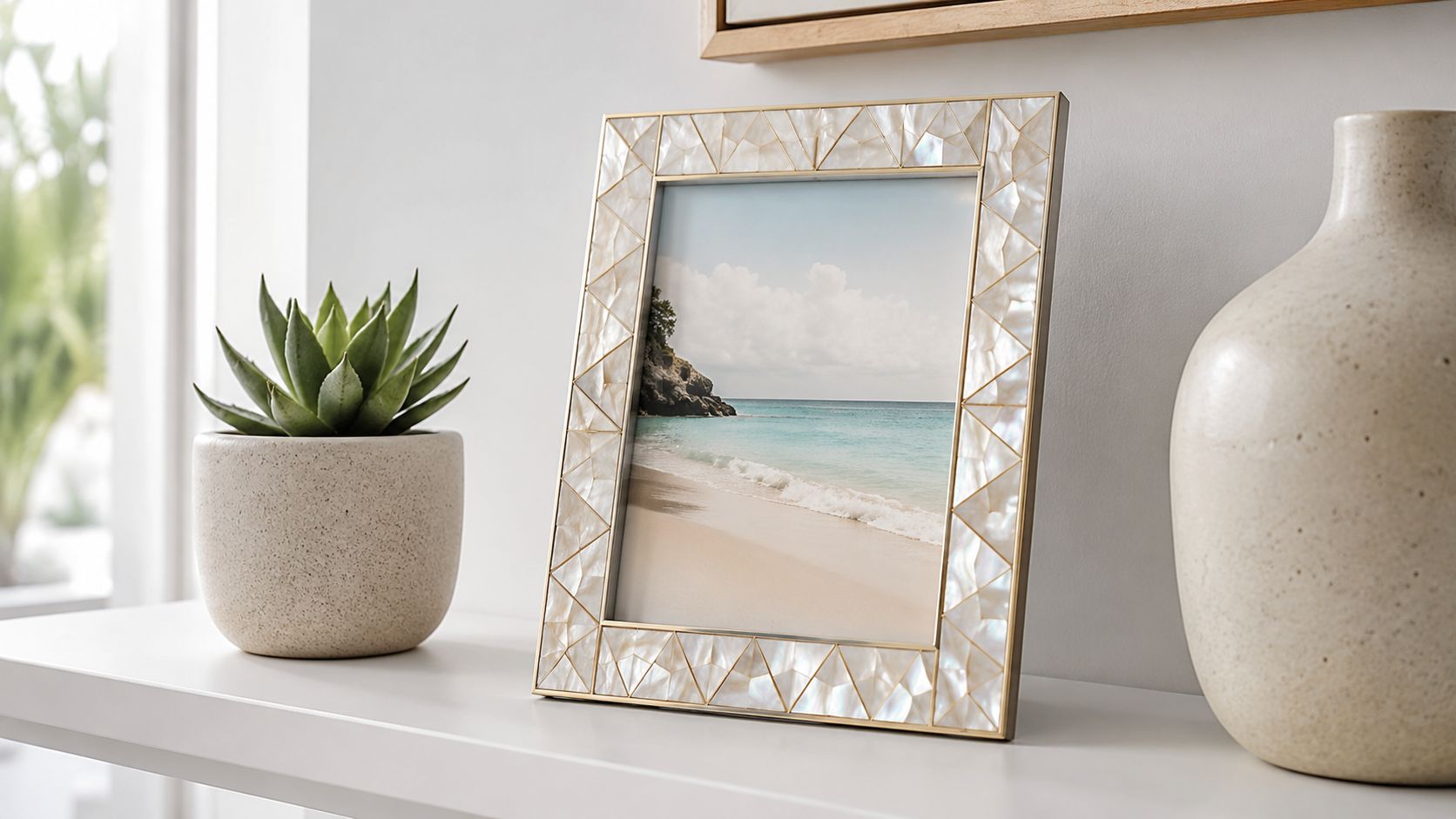A decorative shell photo frame featuring a beach landscape picture, displayed on a shelf with decor.