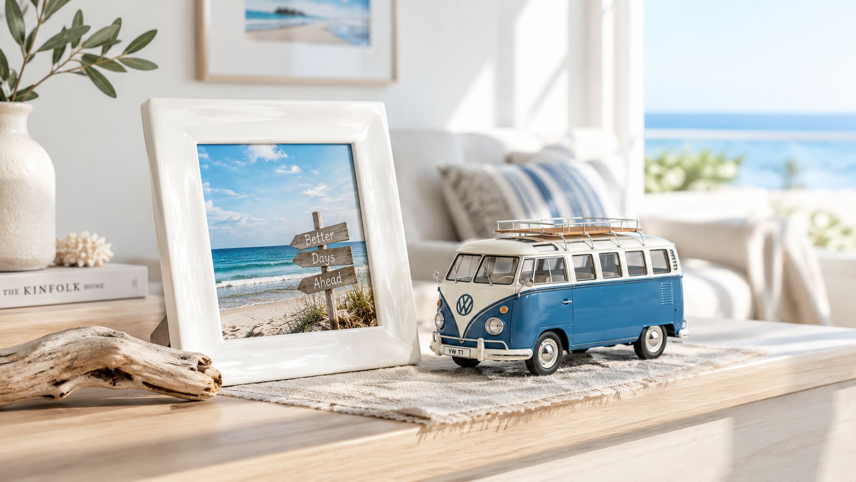 A coastal themed display with a white ceramic photo frame and a blue Volkswagen van model on a wooden table.