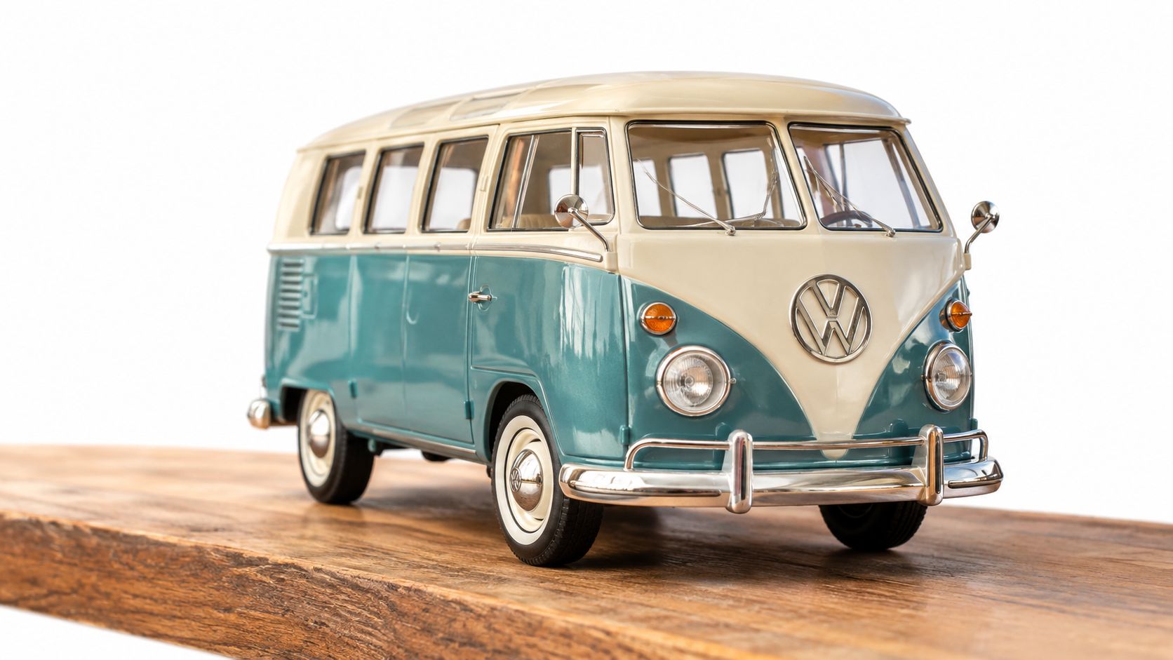 A classic blue and cream colored Volkswagen microbus diecast model sits on a rustic wooden board.