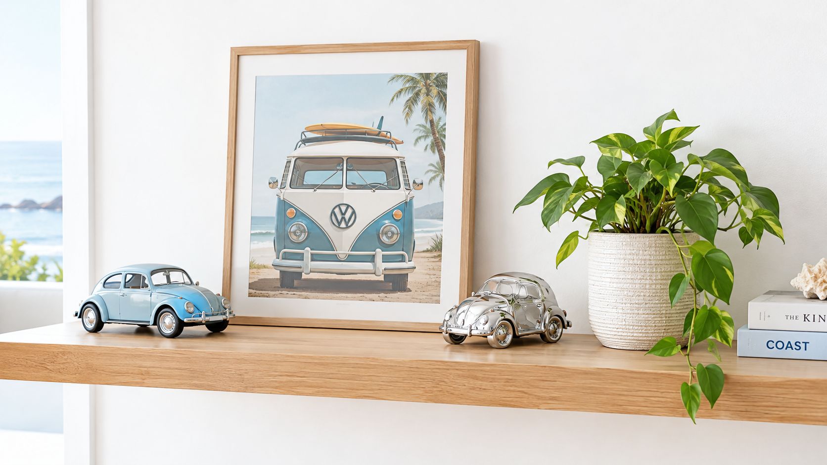 A wooden shelf displays two Volkswagen toy car models, a framed beach van print, and a potted plant.